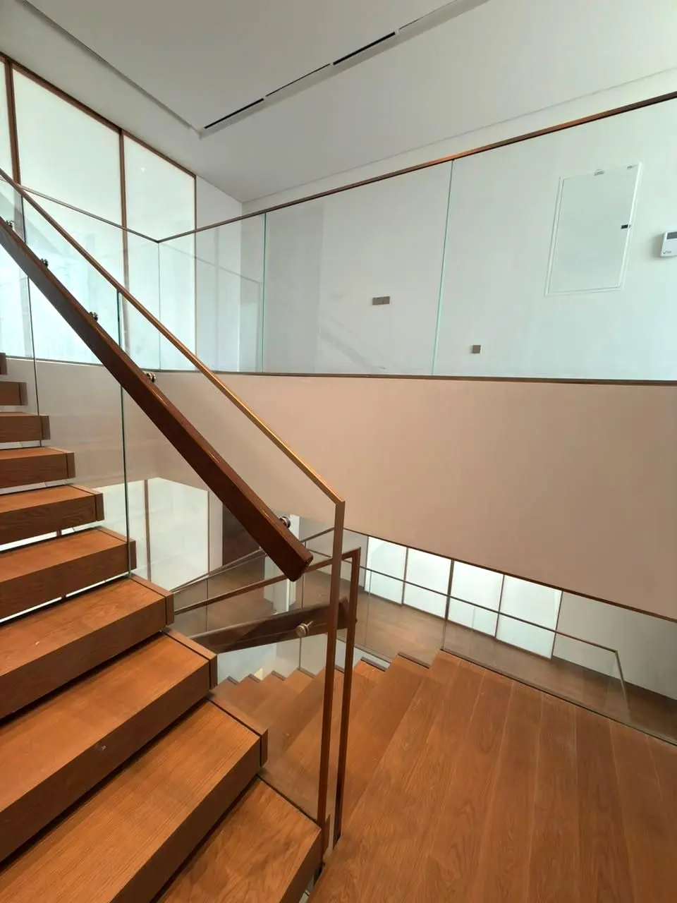 Timber treads and glass balustrade on a switchback stair under natural light