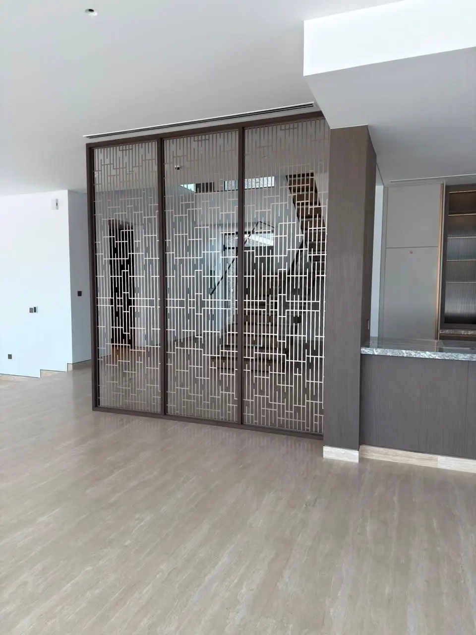 Bronze decorative metal screen panels framing a villa stair void