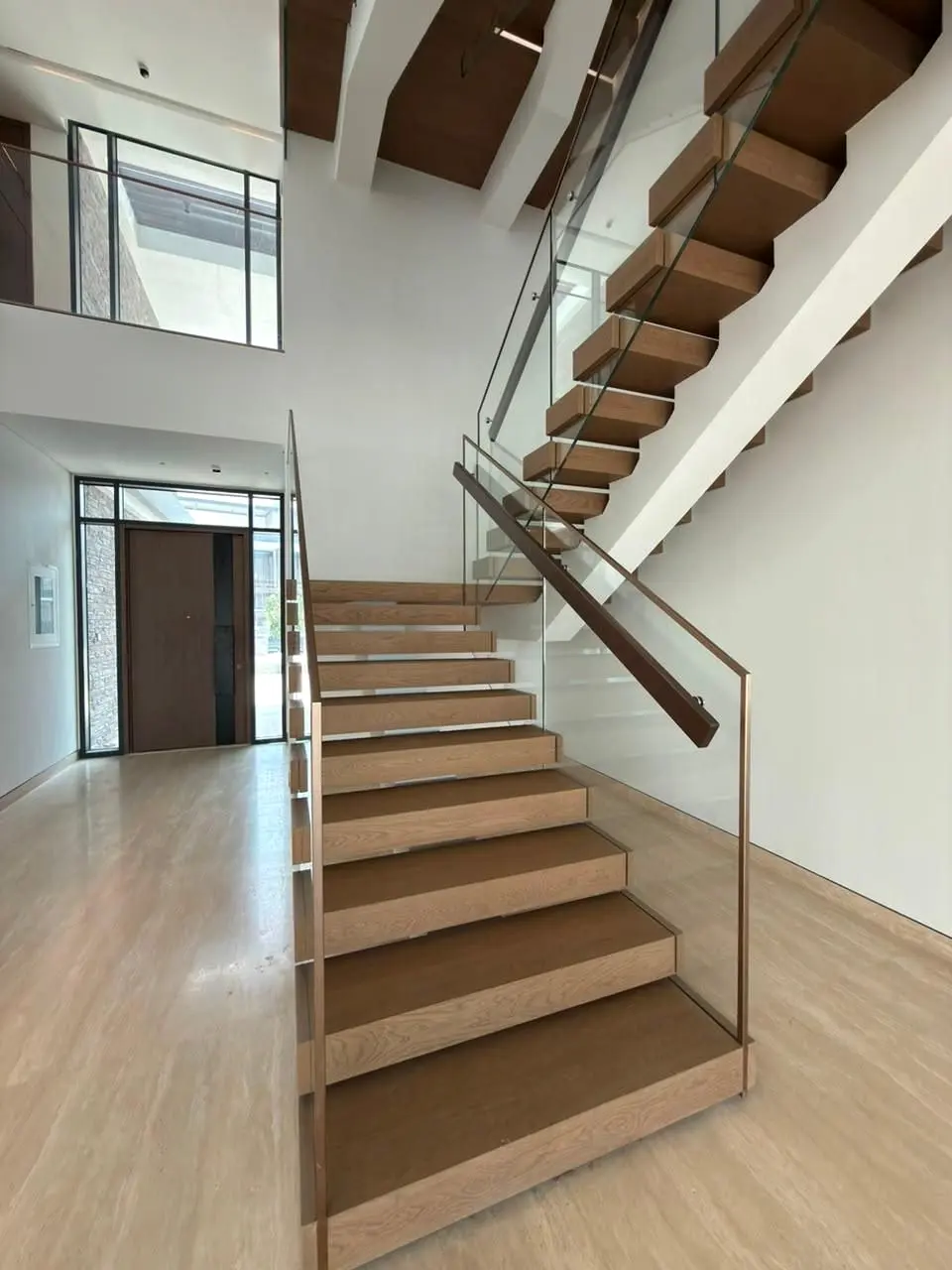 Timber stair flight with glass balustrade leading from the entrance hall
