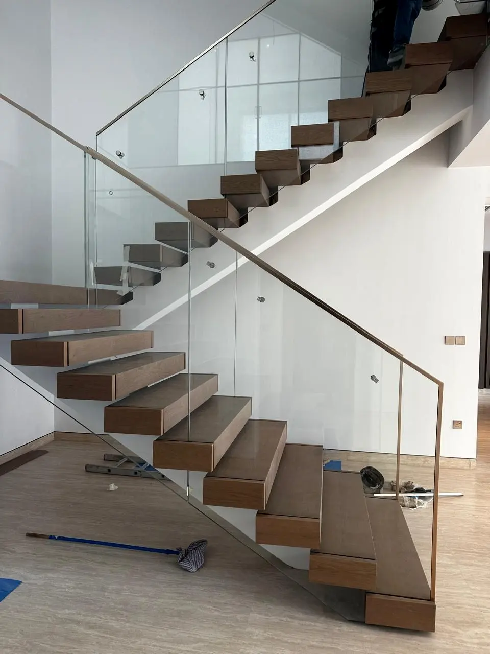Floating timber stair with glass balustrade during final installation