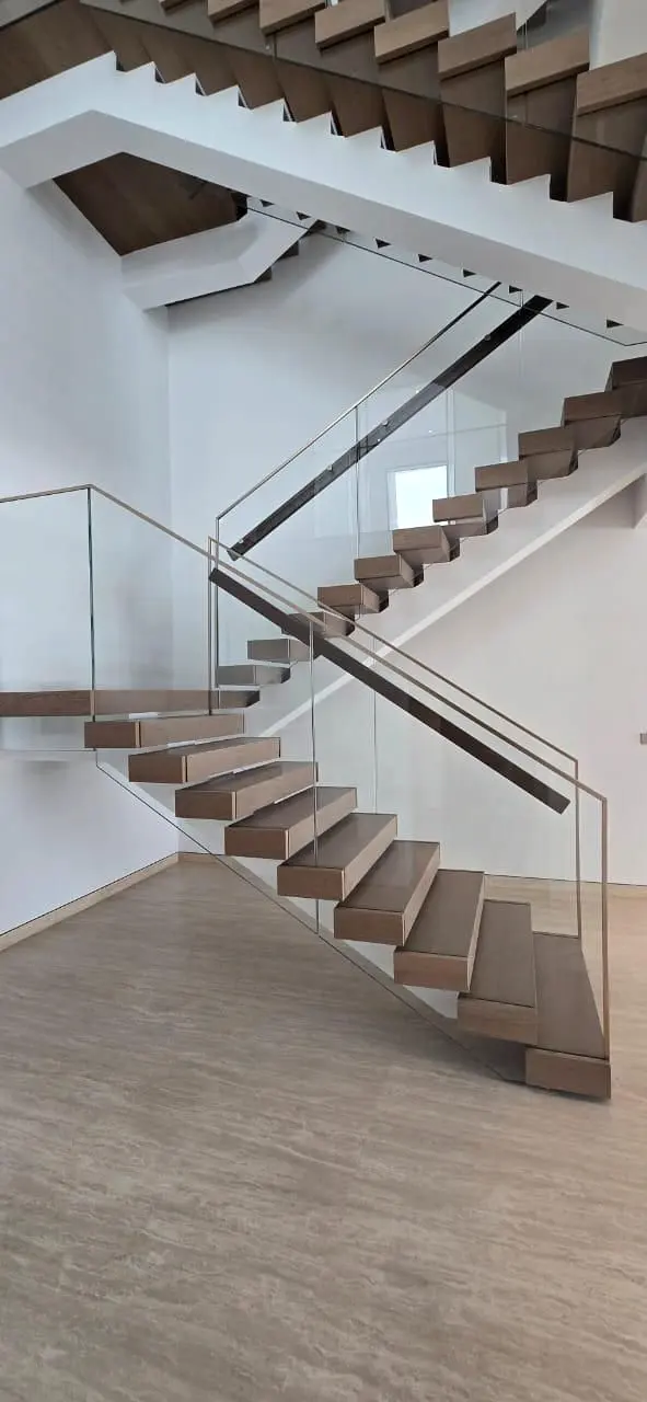 Timber stair and glass balustrade seen from the lower hall