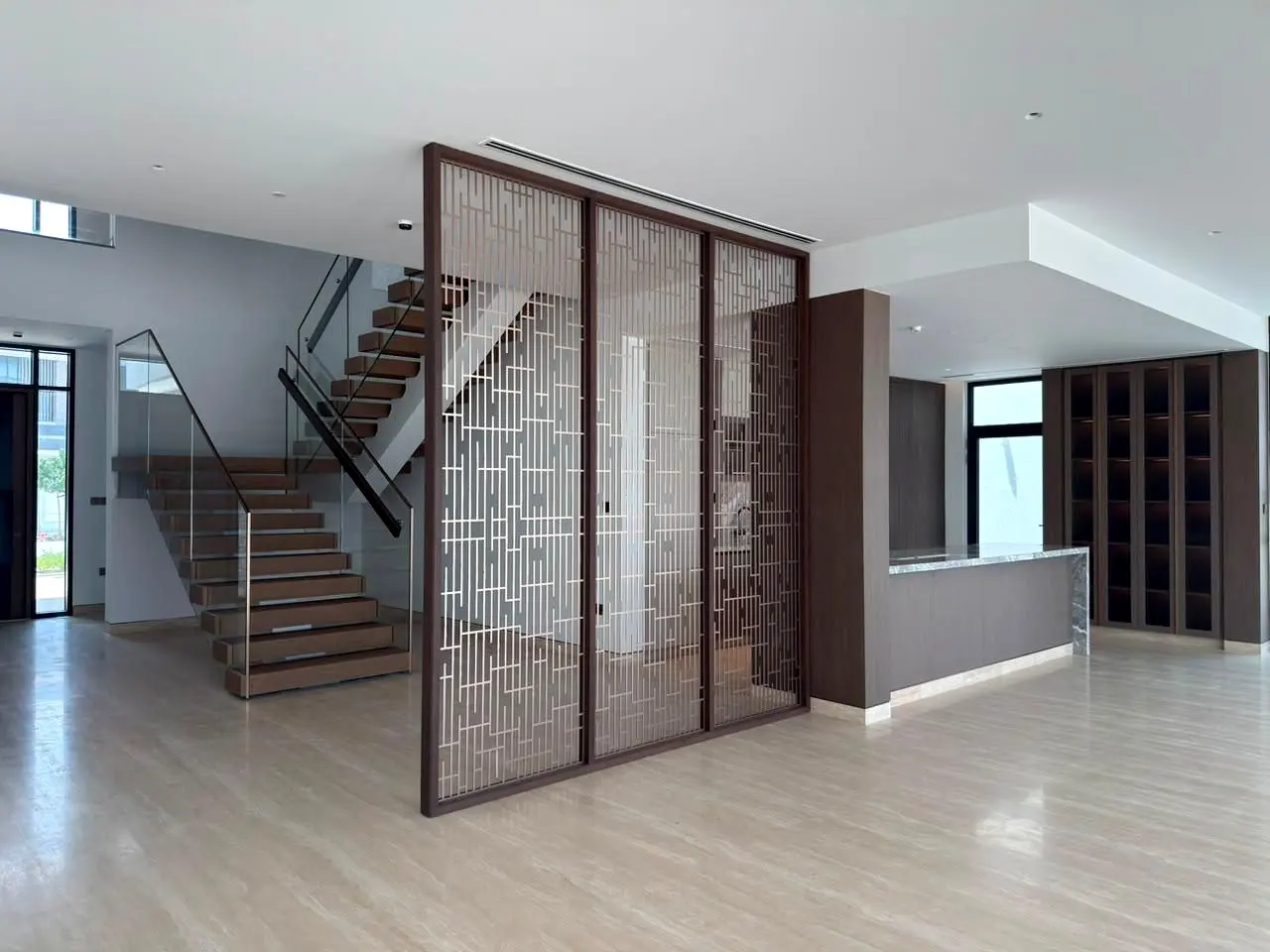 Bronze screen and staircase in an open-plan villa hall