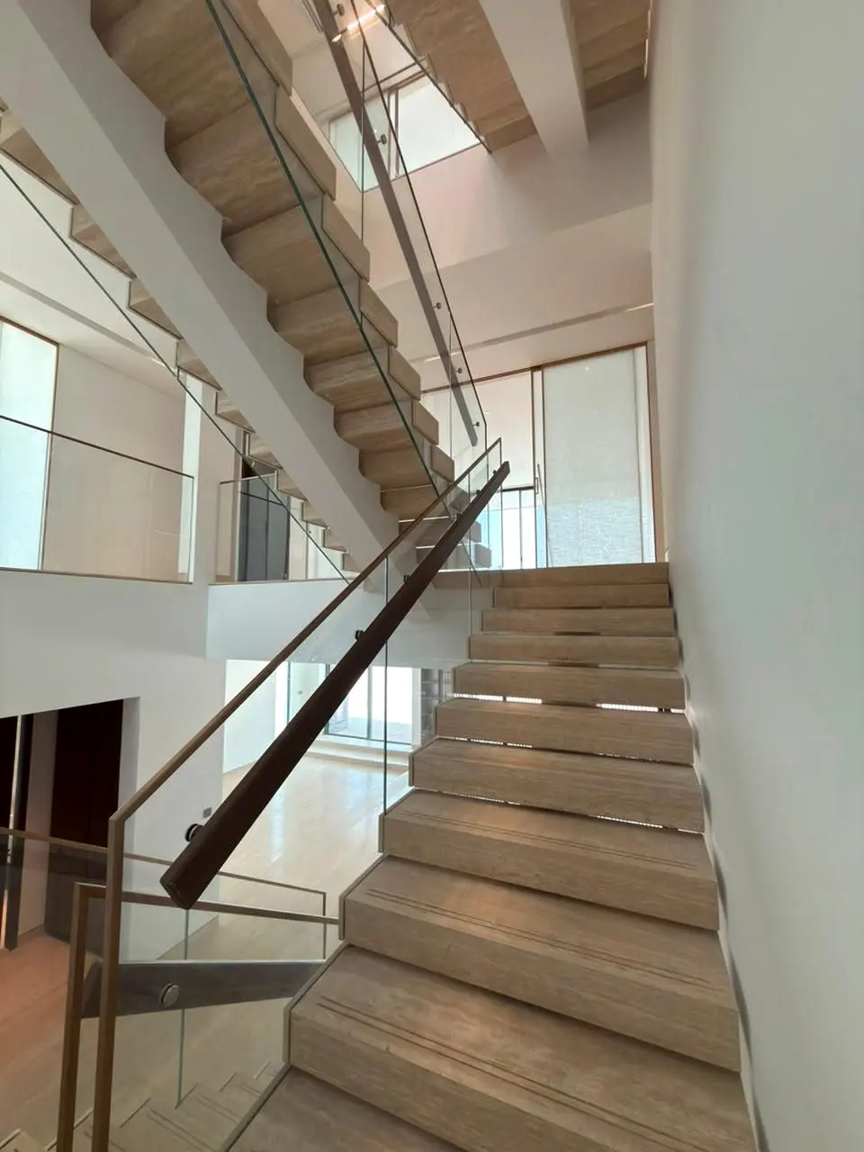 Timber stair with glass balustrade viewed up the flight