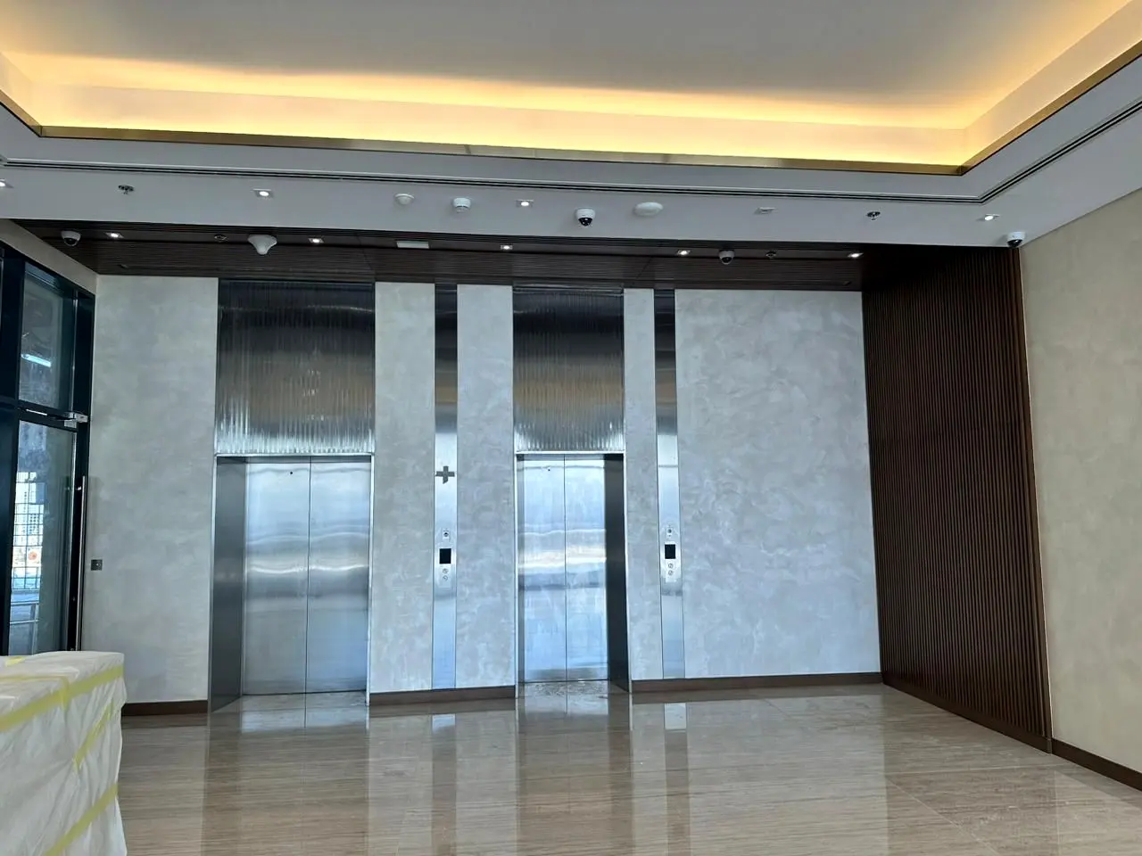 Lift lobby with stainless doors and marble cladding