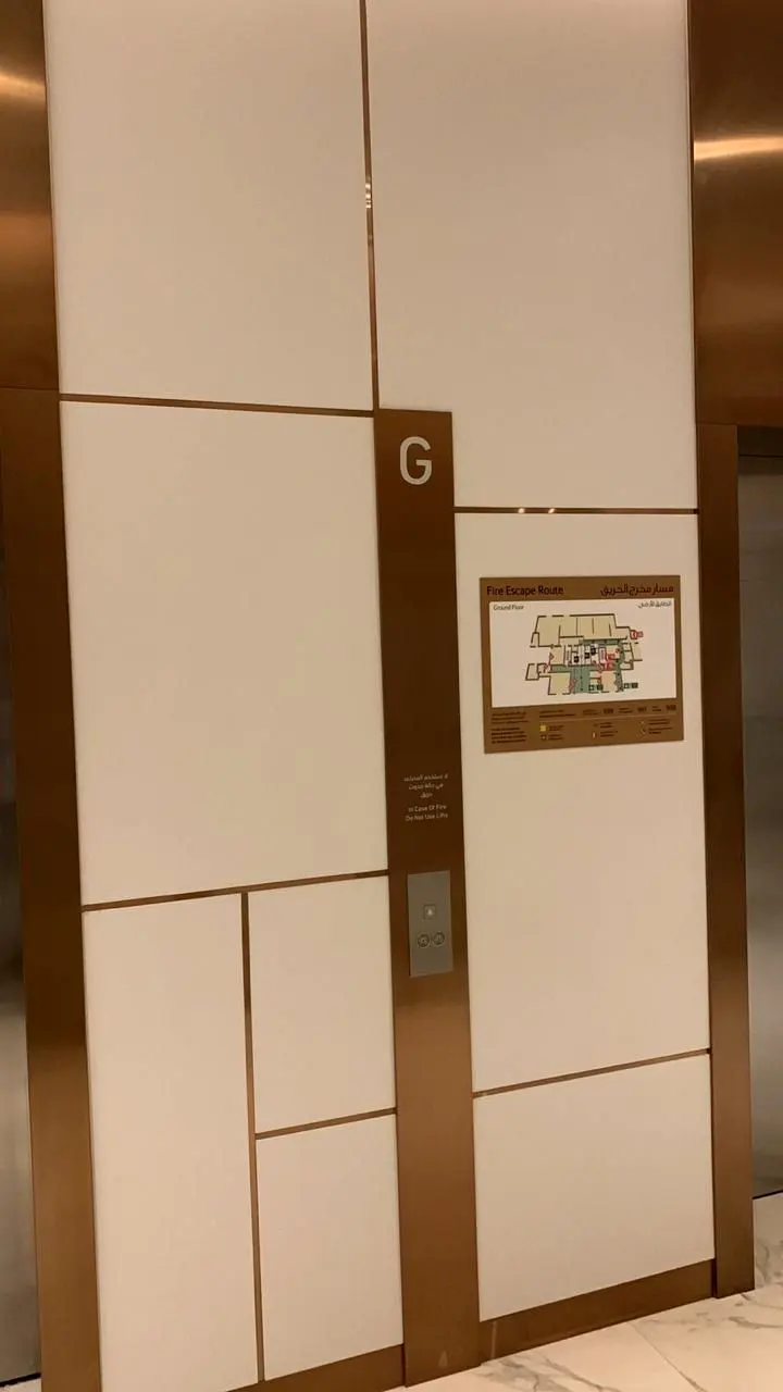 Timber and white panel cladding with floor signage at the lift lobby