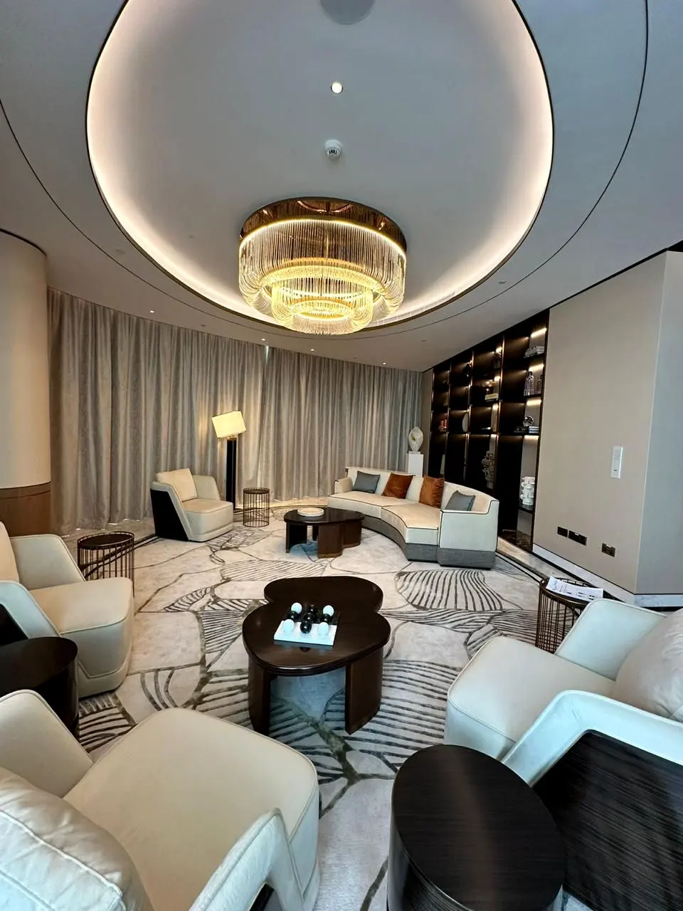 Marsa Al Arab hotel suite lounge under a lit oval ceiling with a crystal chandelier