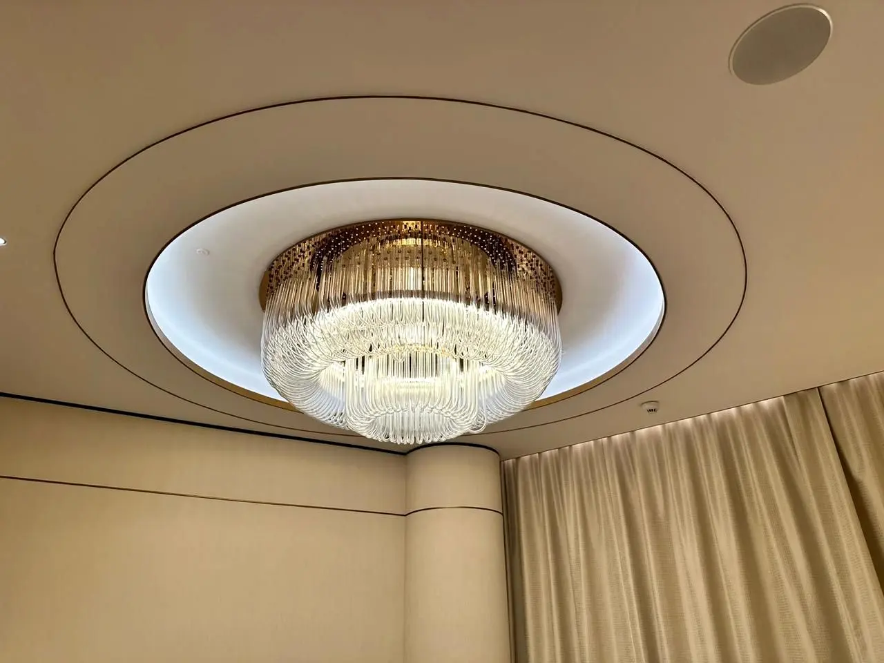 Crystal chandelier set in a lit circular false ceiling