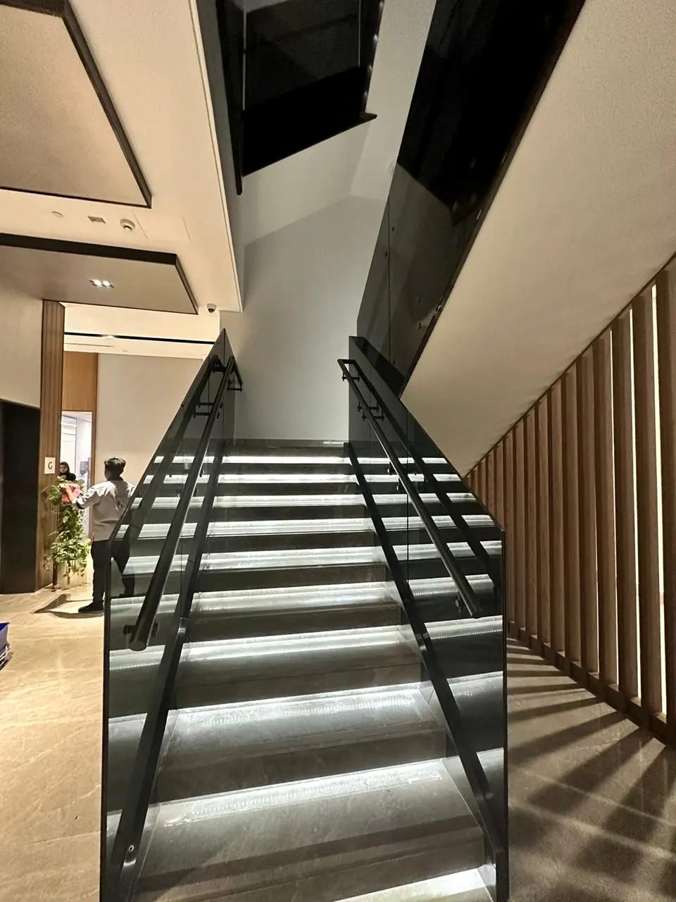 Staircase with black metal balustrade and linear step lighting