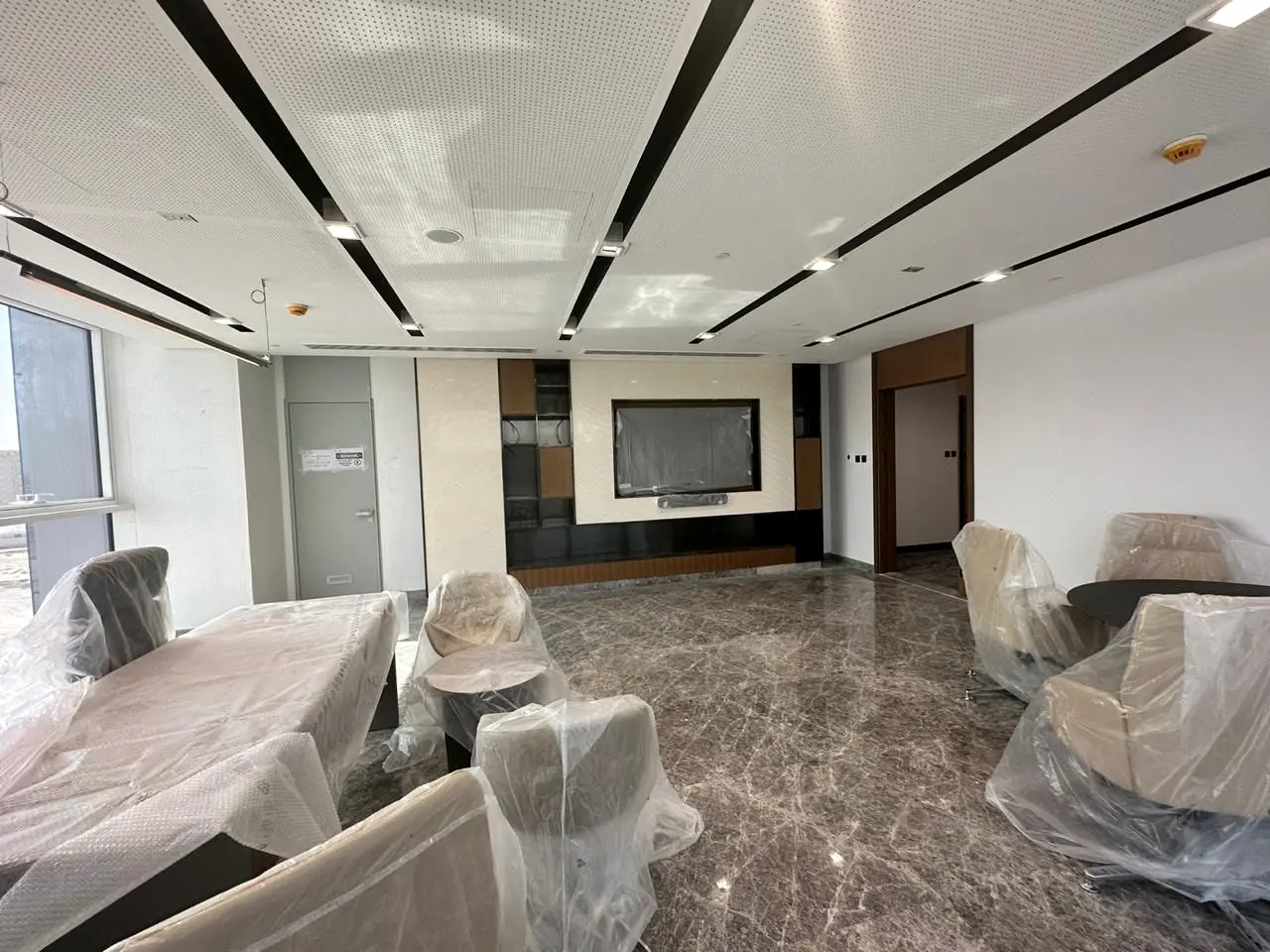 Lounge with suspended ceiling detail and stone floor