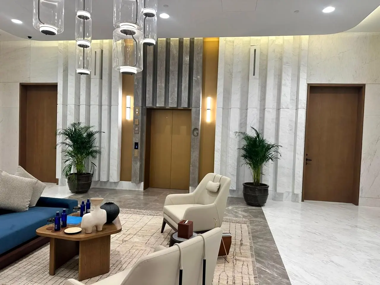 Six Senses residential lobby lounge with feature pendant lighting and stone-clad walls
