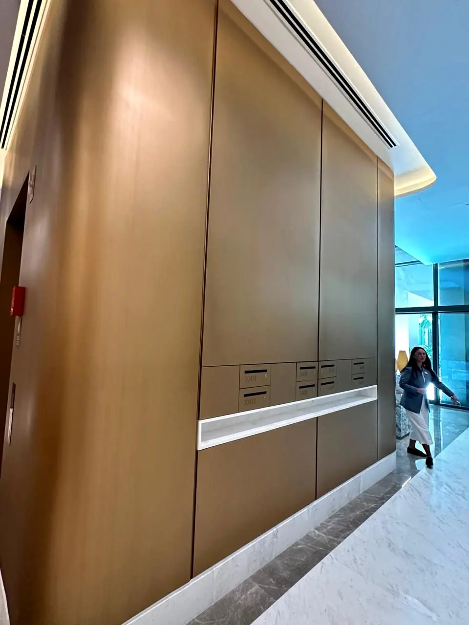 Curved bronze-finish wall cladding with integrated joinery