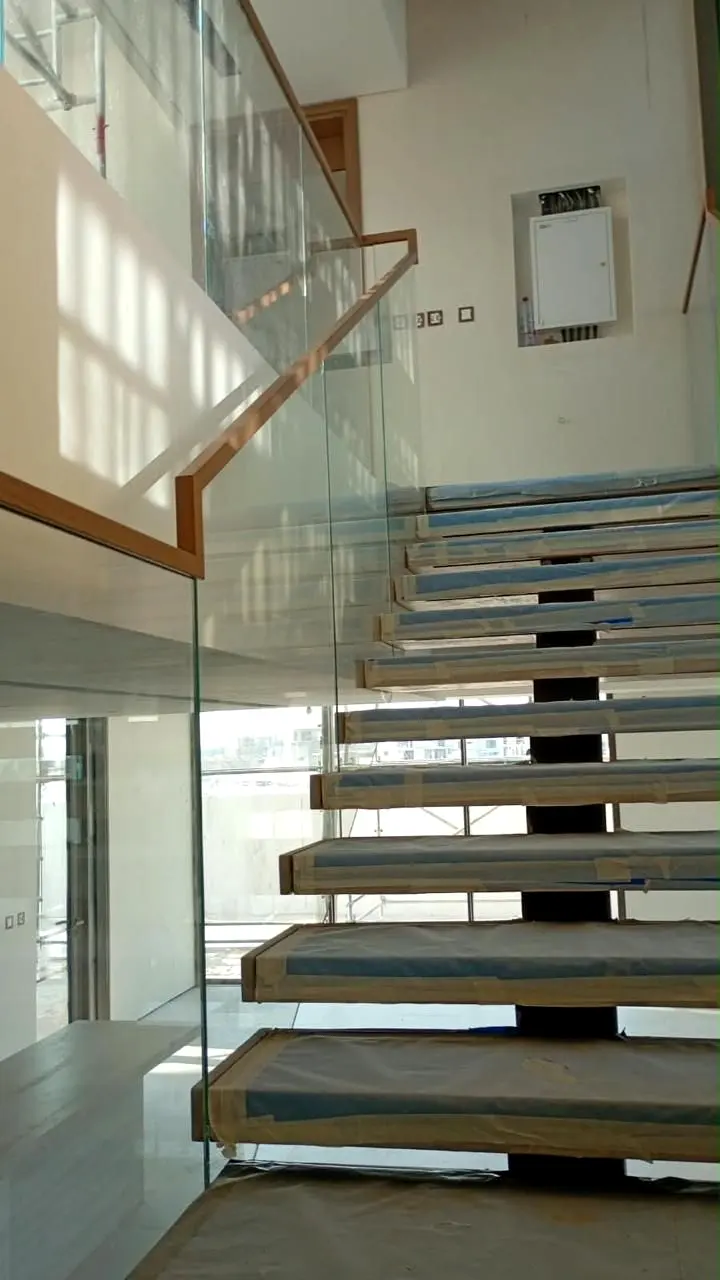 Open-riser stair with frameless glass balustrade and timber handrail