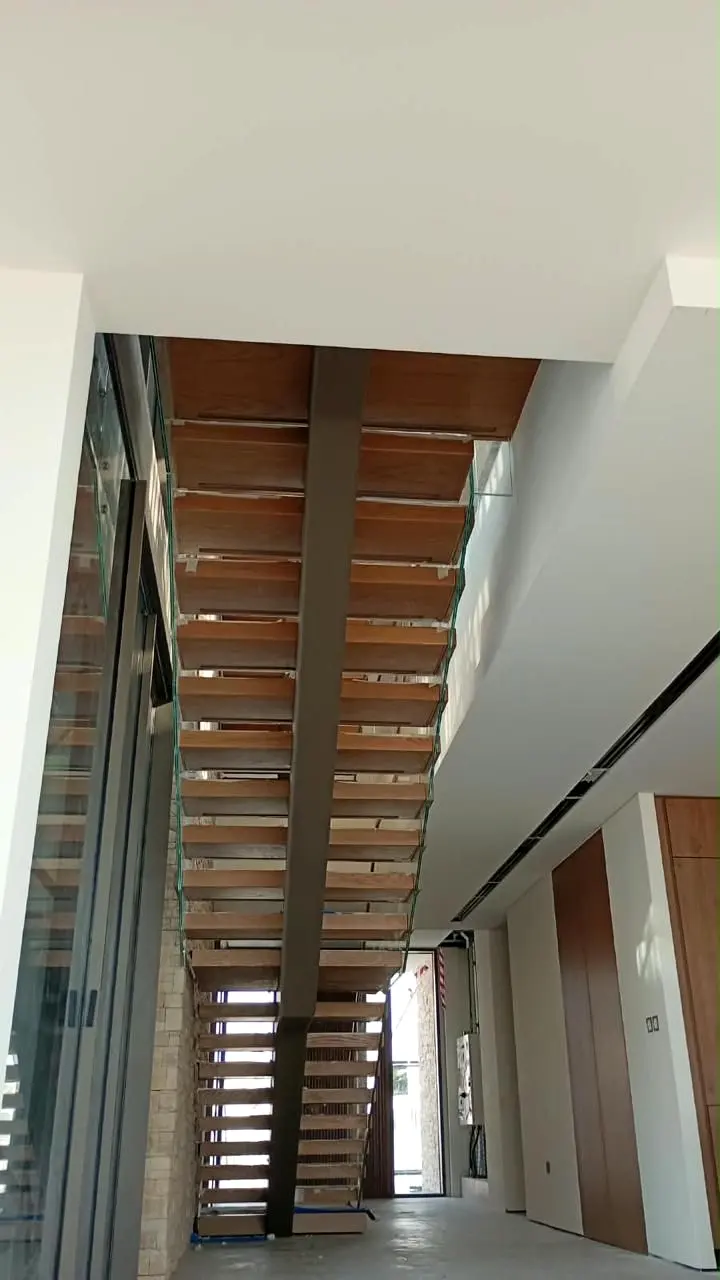 Steel stringer staircase with timber treads rising through a stair core